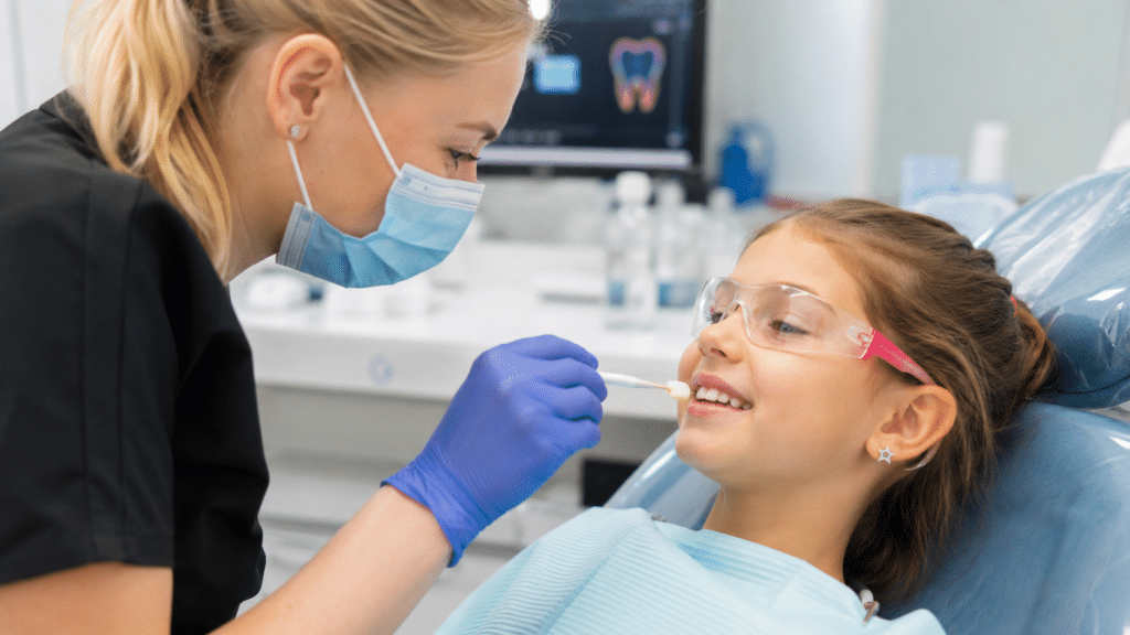 Dentist applying a protective fluoride treatment to a child's teeth.