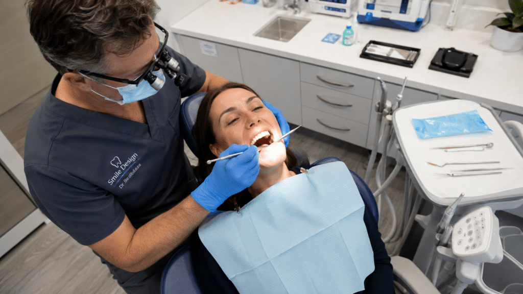 Dentist performing a scale and clean to prepare a patient's teeth for whitening.